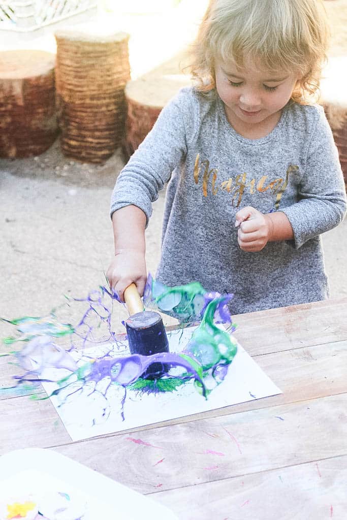 girl hitting paint with mallet